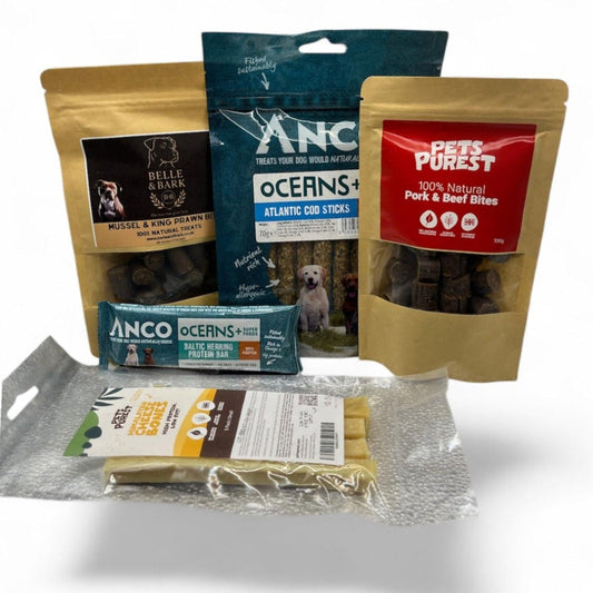 Assorted dog treat packages from different brands on a white background